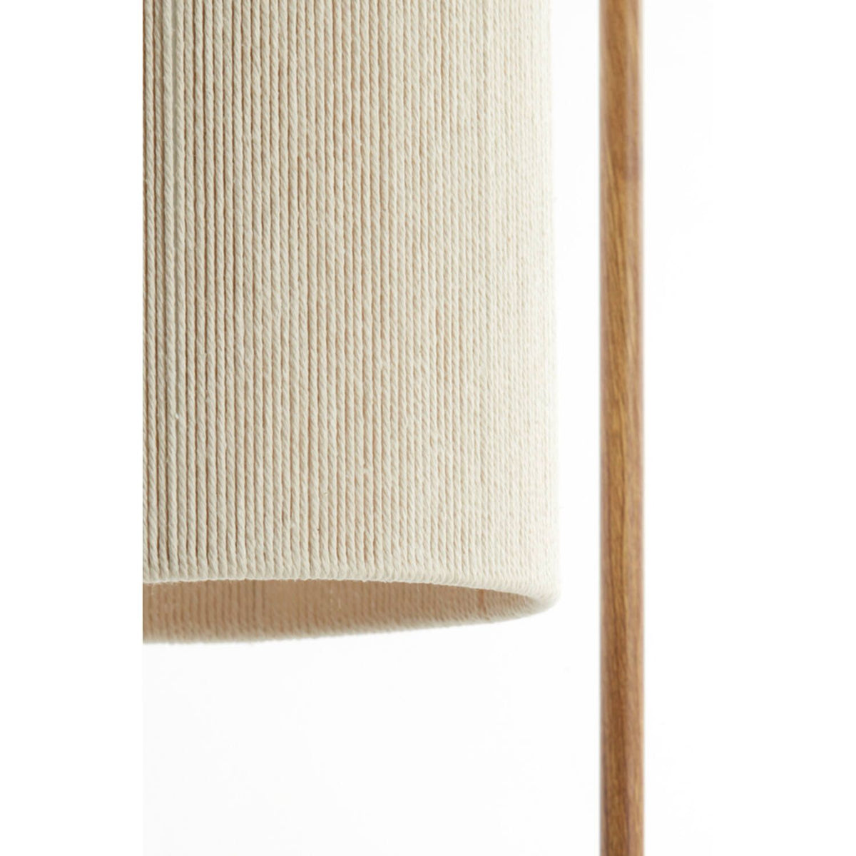 Close-up van een lampenkap omwikkeld met crèmekleurig garen naast een houten lantaarnpaal.