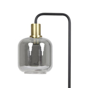 Moderne lamp in zwart en goud met een kap van rookkleurig glas.