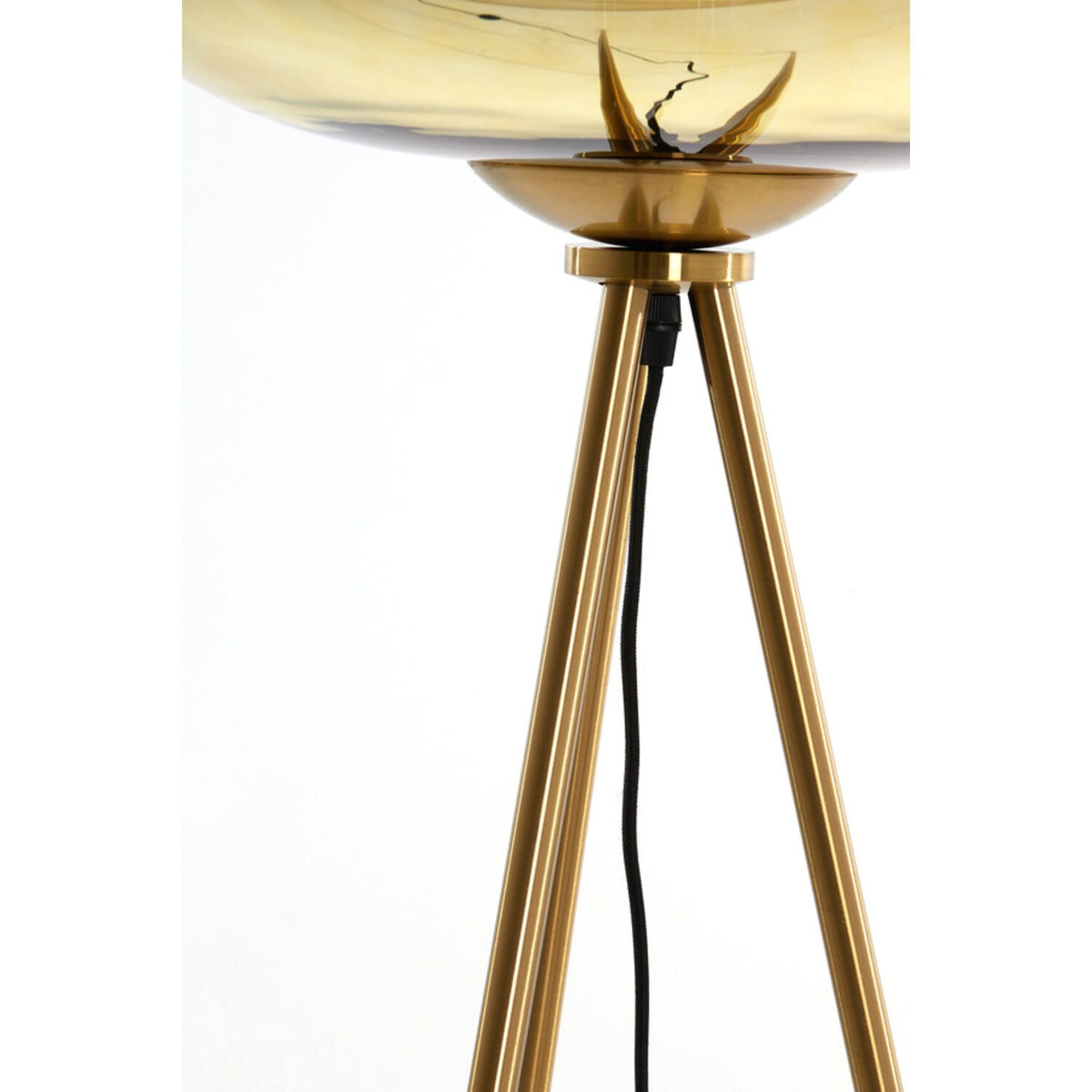 Goudkleurige staande lamp op een statief met een brede, amberkleurige lampenkap. Zwart netsnoer zichtbaar.