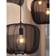 Twee zwarte hanglampen van gaas met zichtbare lampen, hangend binnenshuis.