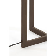 Bruine metalen lampvoet met een zwart netsnoer tegen een witte achtergrond.