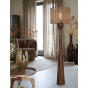 Woonkamer met een staande lamp en decoratieve items in neutrale tinten.