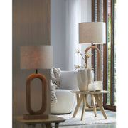 Tafellamp en staande lamp met neutrale kappen in een woonkamer. Bijzettafel met vaas en kaars.