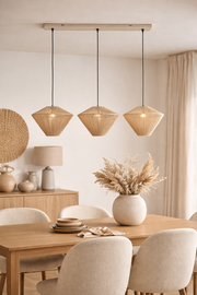 Eetkamer met houten tafel, beige stoelen en drie geweven hanglampen.